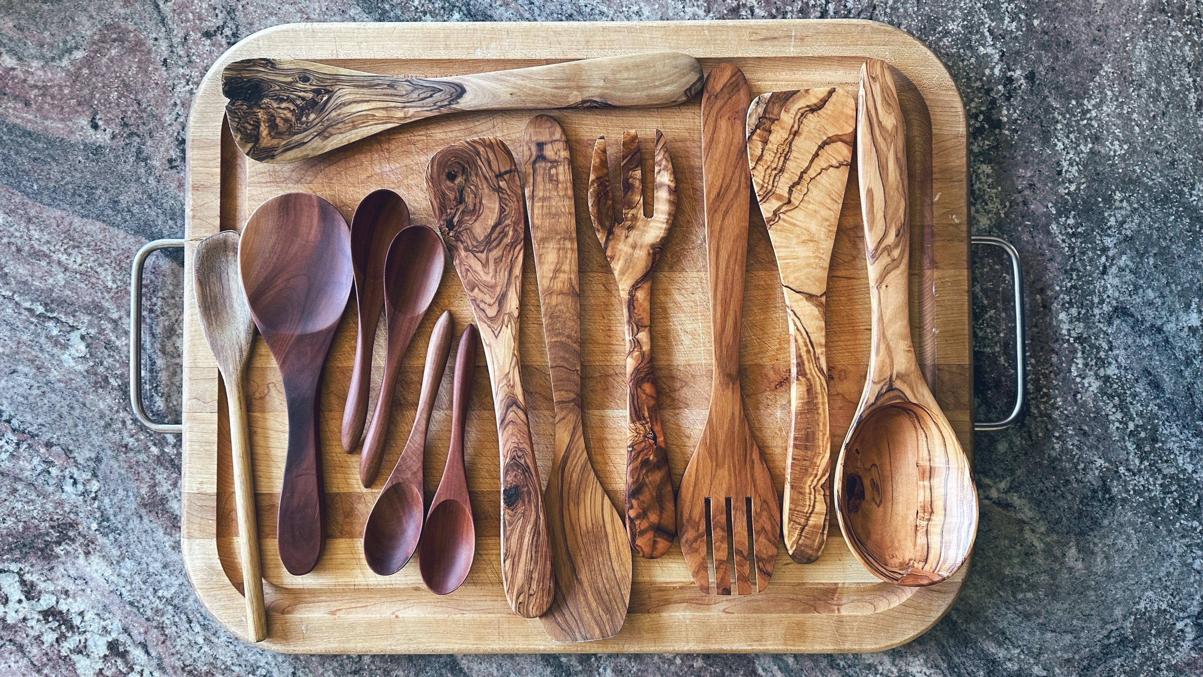A collection of freshly polished wooden spoons and serving utensils.