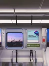 The inside of a BART train, with the window overlooking the Oakland raising cranes at sunrise