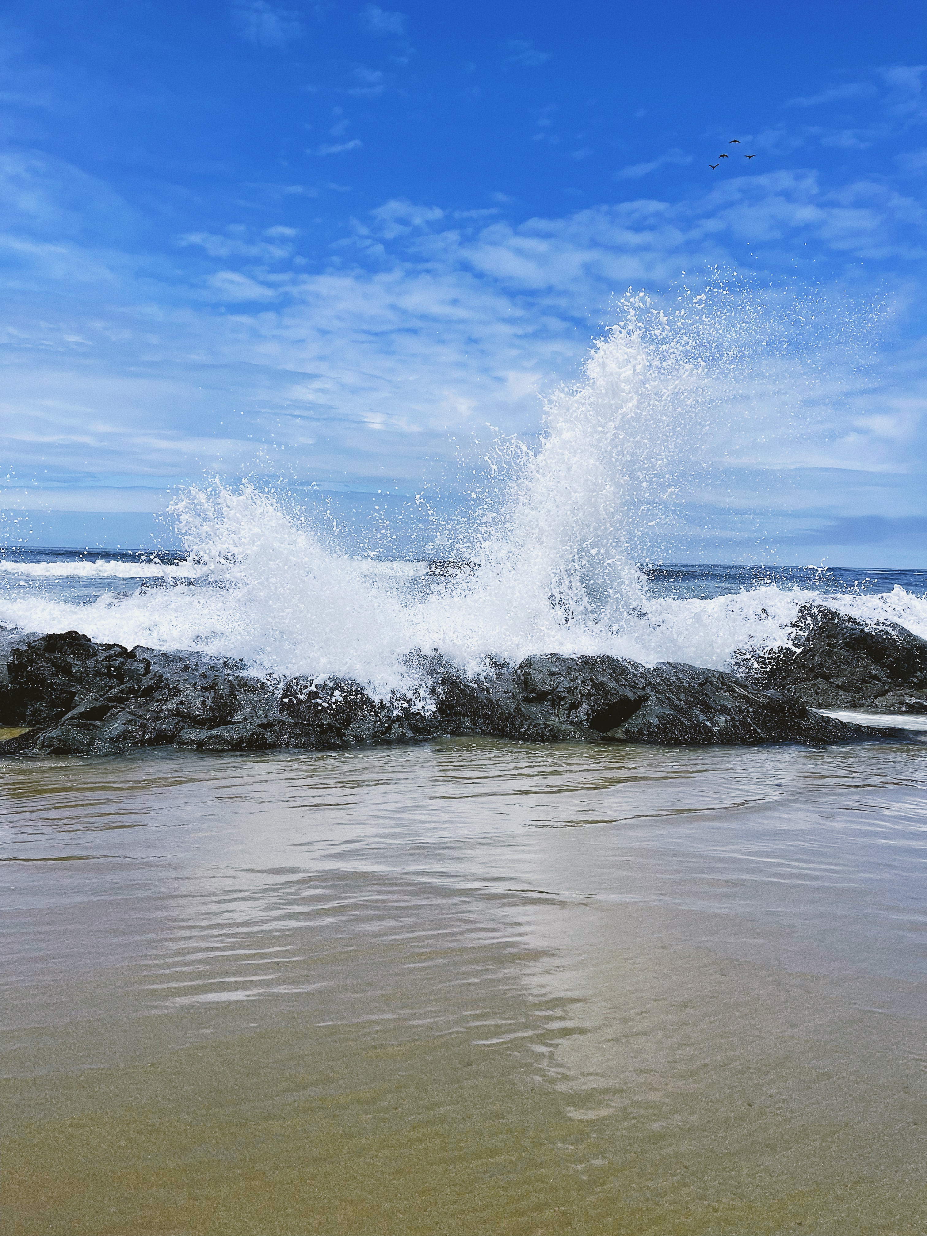Ocean waves crashing against the rocks and spraying the air at Kehoe Beach.